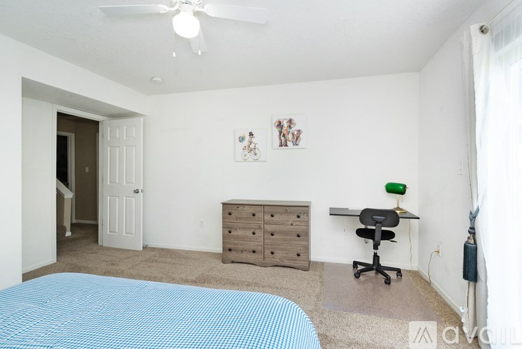 A bedroom with a bed, dresser, and chair.