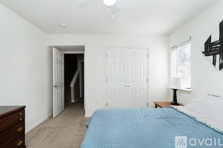 A bedroom with a bed, dresser, and a window.
