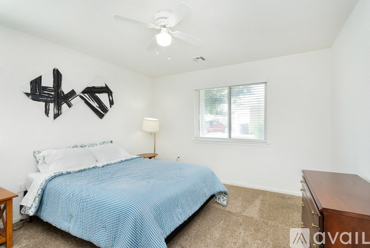 A bedroom with a bed, a window, and a ceiling fan.