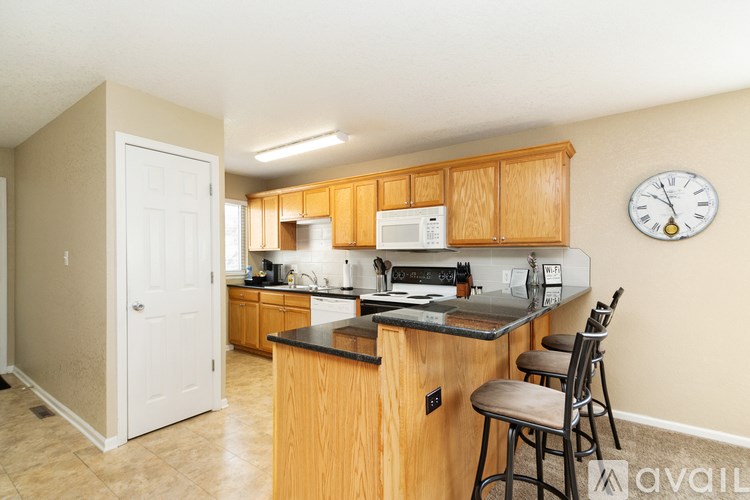 A kitchen with wooden cabinets and a black countertop.