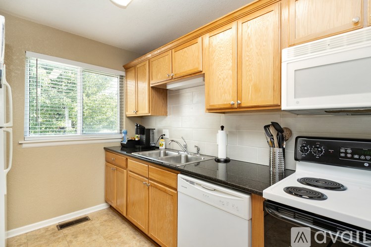 A kitchen with wooden cabinets and white appliances.