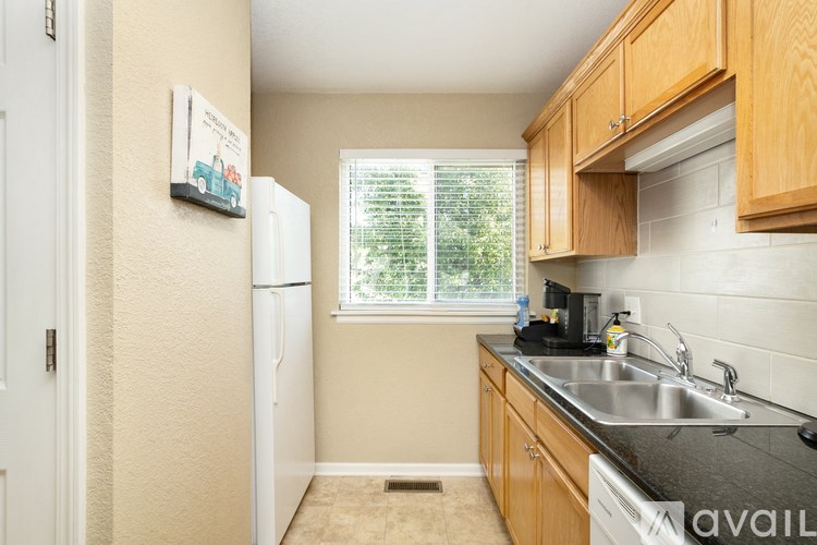 A kitchen with a white fridge and wooden cabinets.
