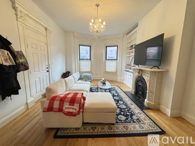 A room with wooden flooring and a chandelier.