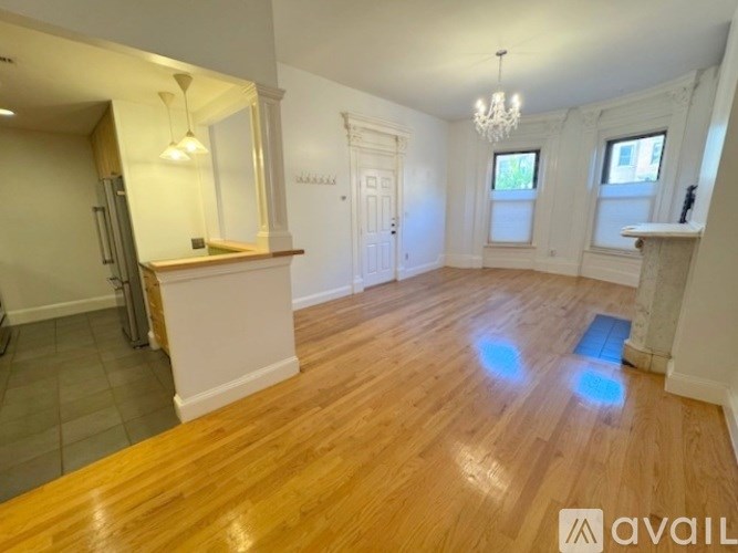 A room with wooden flooring and a chandelier.
