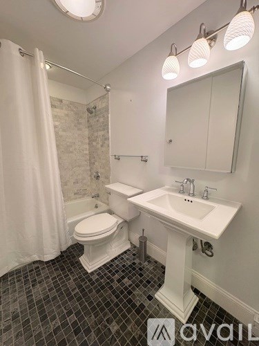 A bathroom with a toilet, sink, and shower.