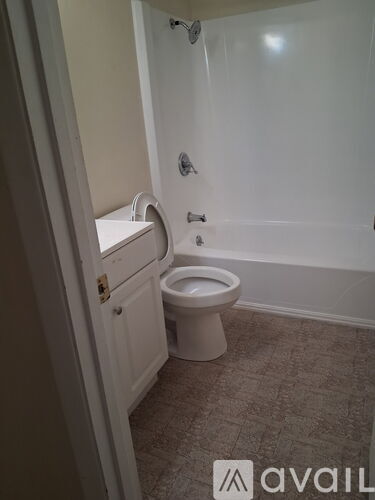 A white toilet in a bathroom with a white cabinet.