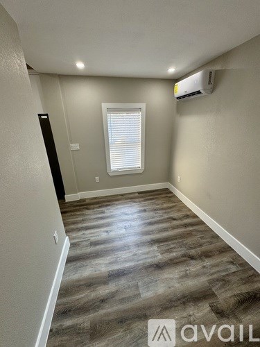 A room with a window and a wall-mounted air conditioner unit.