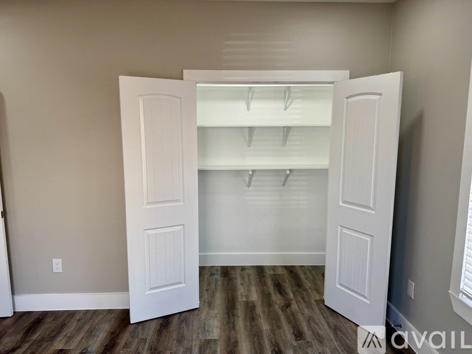 A room with a white door and a wooden floor.