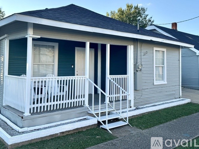 A small house with a porch and a white railing.
