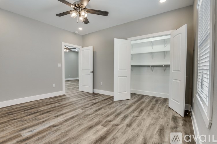 A room with a ceiling fan and a window with blinds.