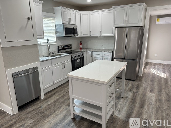 A kitchen with white cabinets and a white island.