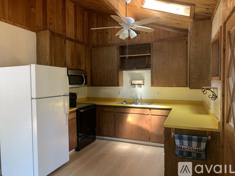 A kitchen with wooden walls and a white refrigerator.