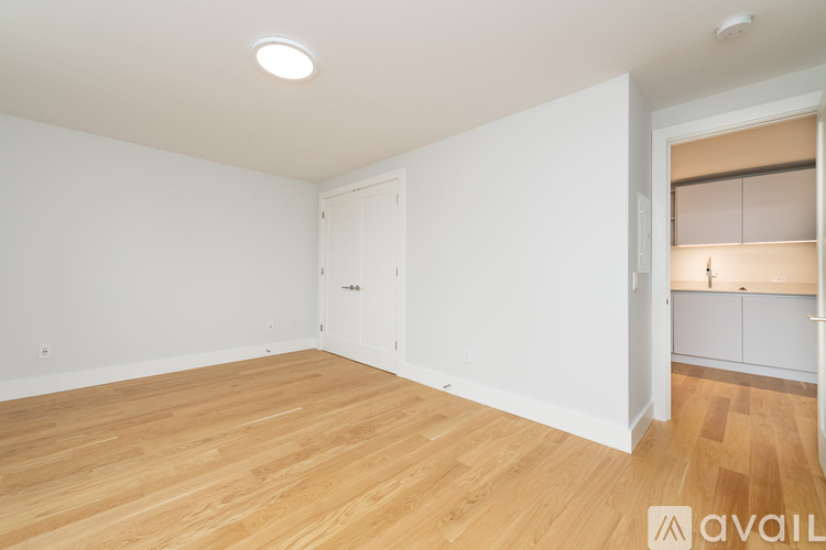 A room with wooden flooring and a white door.