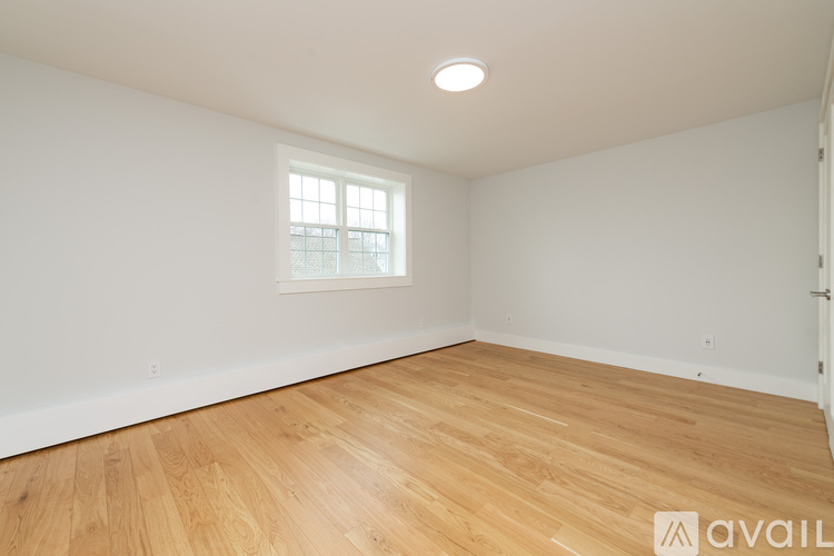 A room with wooden flooring and a window.