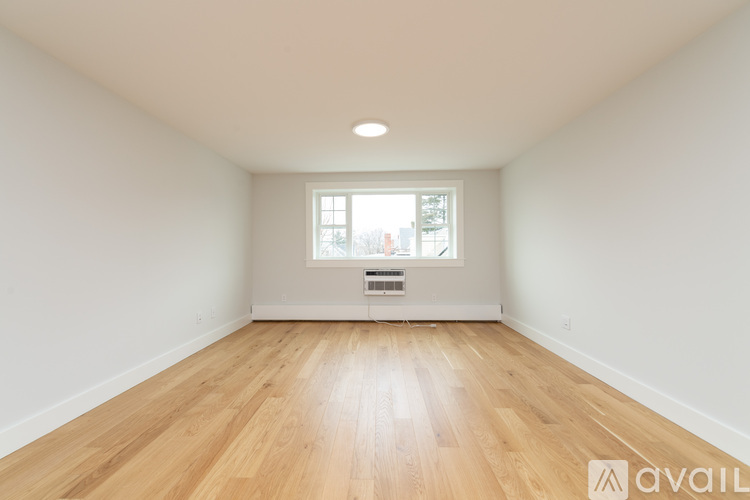 A room with wooden flooring and a window.