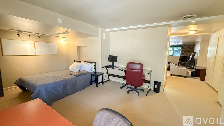 A bedroom with a bed, desk, and chair.