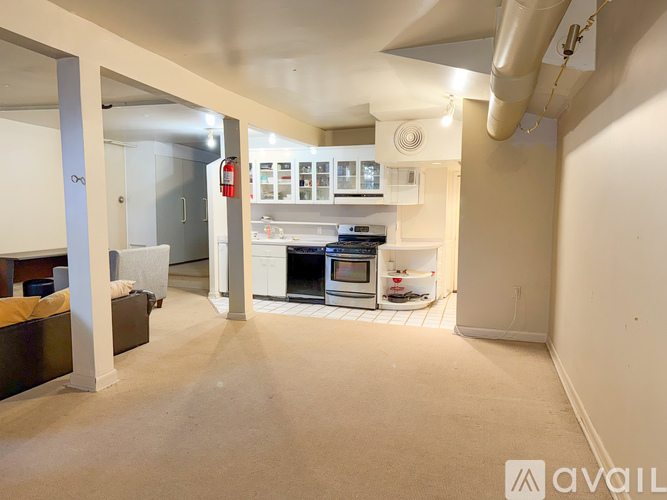 A living room with a couch and a kitchen area in the background.