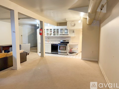 A living room with a couch and a kitchen area in the background.