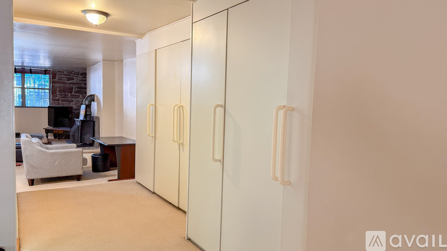 A room with a white chair and a white cabinet.