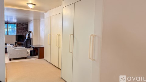A room with a white chair and a white cabinet.