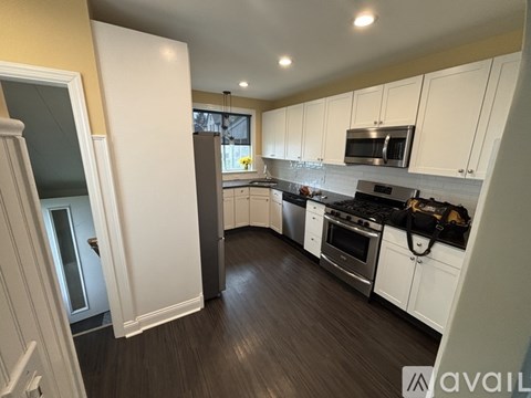 A kitchen with white cabinets and a black stove top oven.