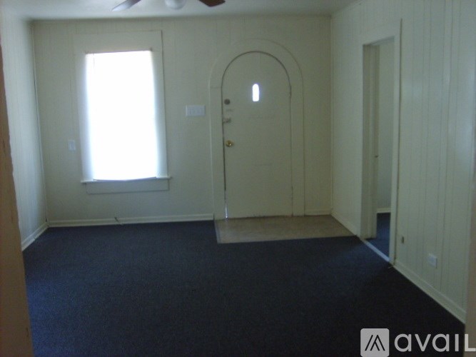 A room with a door, a window, and a ceiling fan.