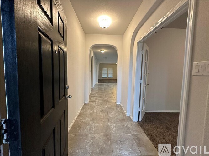 A hallway with a light on and a door on the left.