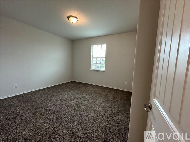 A room with a carpeted floor and a window.
