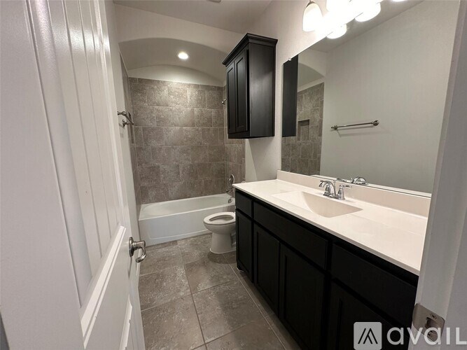 A bathroom with a toilet, sink, and bathtub.
