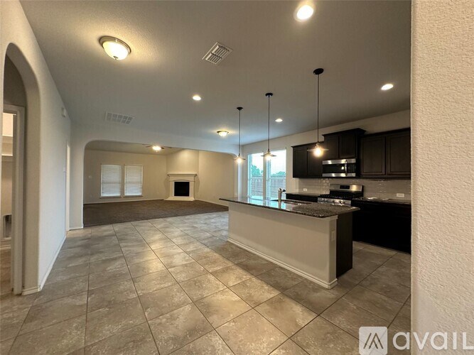 A spacious kitchen with a bar area and a dining area in the background.