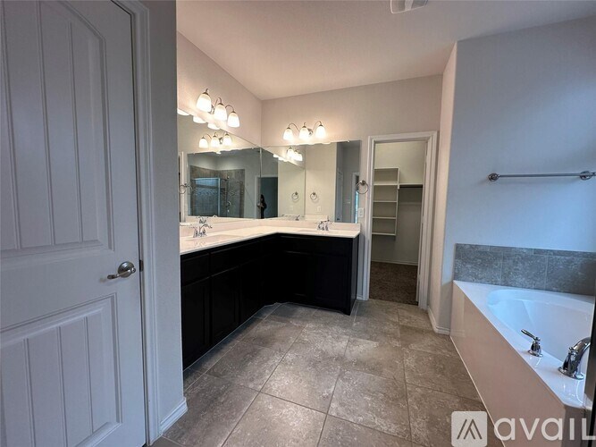 A bathroom with a large mirror and a bathtub.