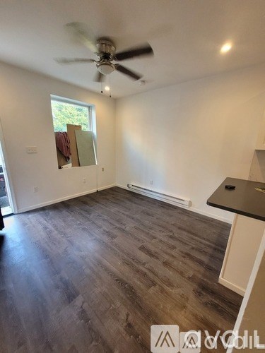 A room with a ceiling fan and a window.