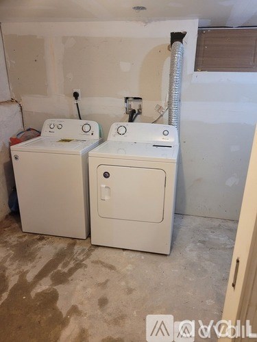 A white washing machine and dryer in a room with white walls.