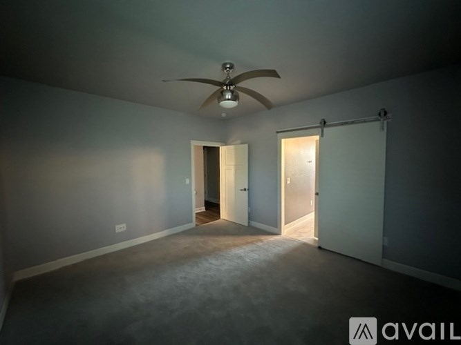 A room with a ceiling fan and two doors.