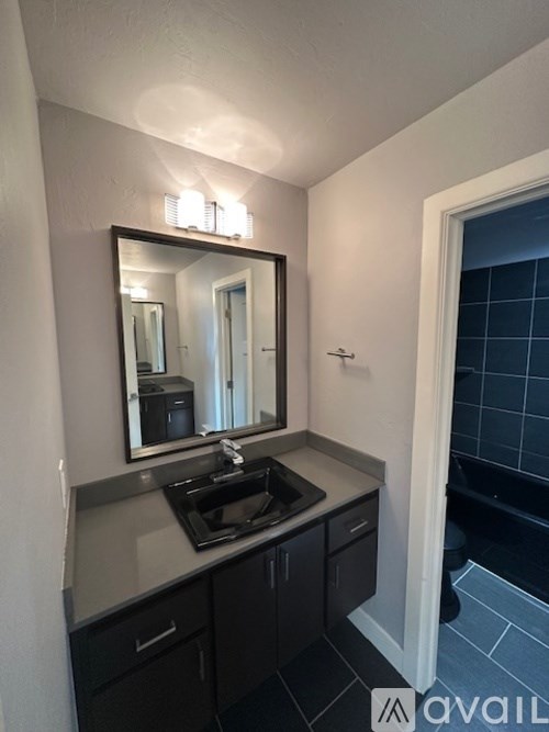 A bathroom with a sink, mirror, and a window.