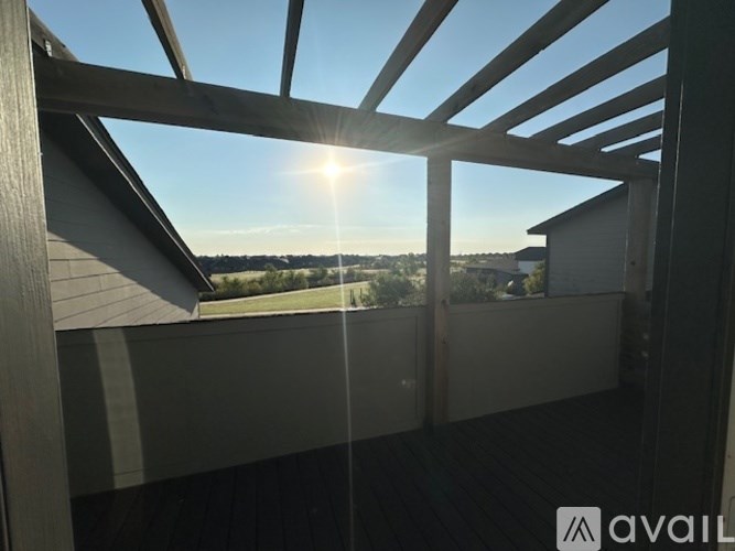 A balcony with a view of the sky and trees.