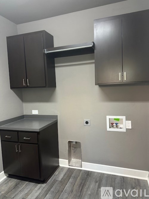 A kitchen area with a black counter and cabinets.