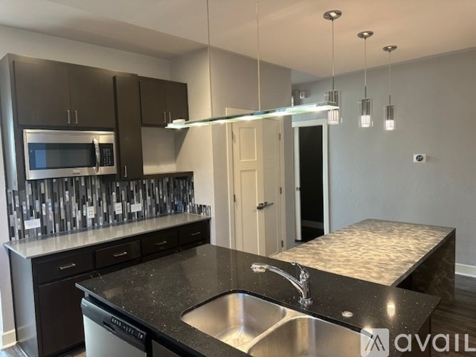 A kitchen with black granite countertops and stainless steel appliances.