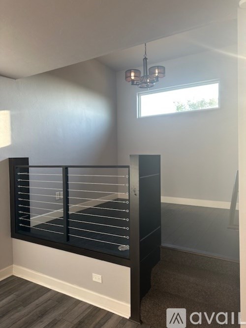 A room with a window and a balcony with a railing.