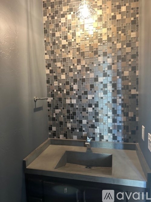 A bathroom with a black and white tiled shower area.