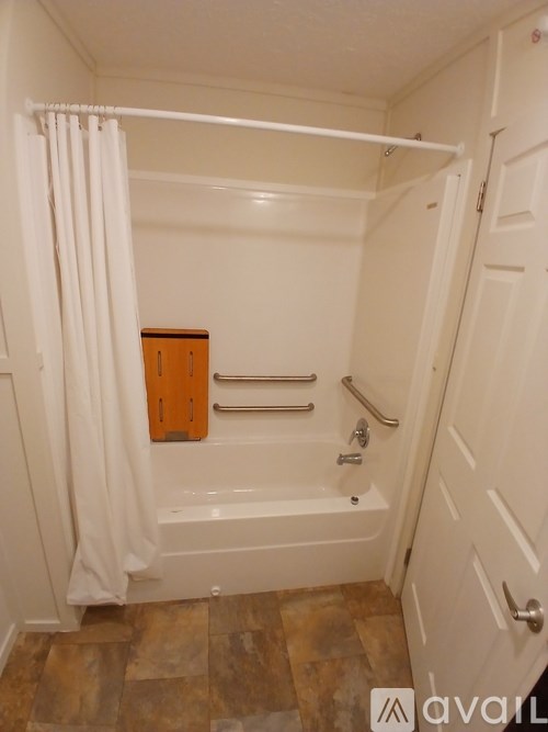 A bathroom with a tub and a wooden cabinet.