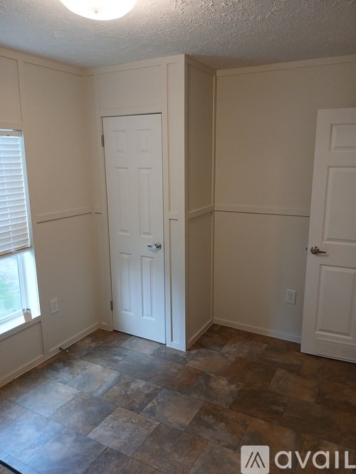 A room with a tile floor and two white doors.