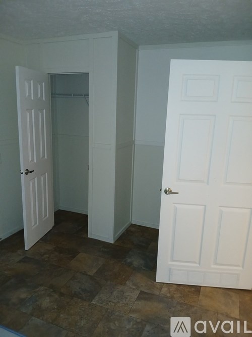 A room with two white doors and a tiled floor.
