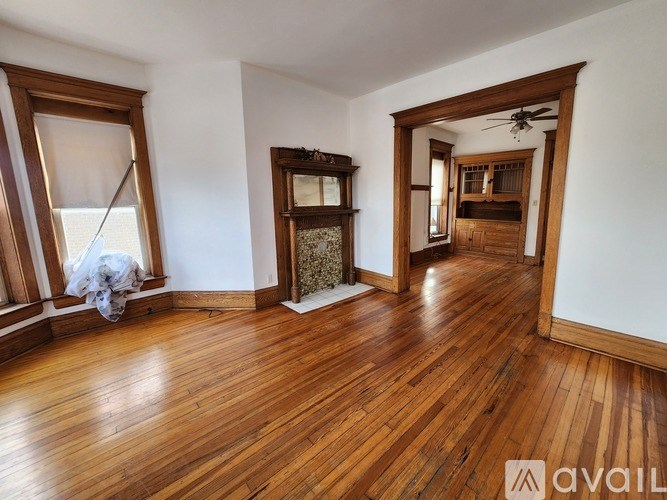 A room with wooden floors and a large mirror on the wall.