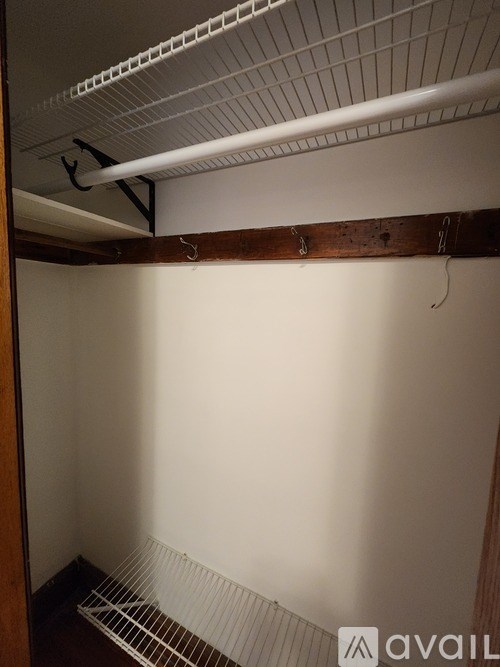 A room with wooden floors and a window showing a brick building outside.