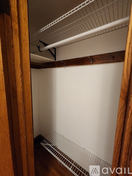 A small, empty closet with a wooden door.