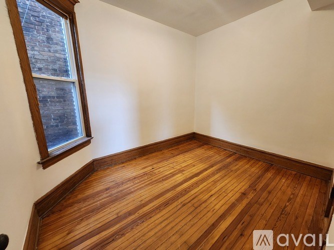A room with wooden flooring and a window.