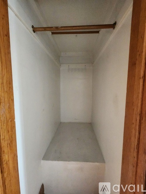A small, empty room with a concrete floor and white walls.