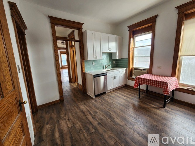 A kitchen with wooden floors and white walls.