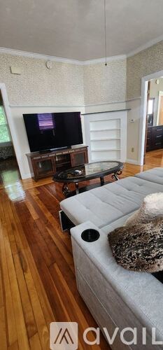 A living room with a couch, a coffee table, and a large window.